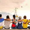 people holding shoulders sitting on wall